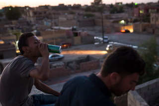 16/09/2016 - Snuny, Iraq: Saadon and his friend Najiman sit on the roof of an uncle´s house in Snuny and drink beers. He isn´t able to visit Sinjar often since his family was displaced.